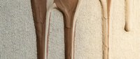 Wooden spoons in various shades arranged on neutral linen fabric, showcasing kitchen utensils for cooking, baking, and culinary design projects.