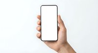 Hand holding modern smartphone with blank white screen mockup for app presentation and mobile interface design on clean background.