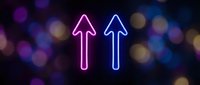 Two glowing neon arrows pointing upward in pink and blue colors against dark bokeh background for business growth and progress concepts.