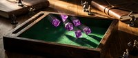 Tabletop gaming setup with purple polyhedral dice rolling on green felt surface inside wooden dice tray, surrounded by miniatures and gaming accessories for fantasy role-playing campaigns.