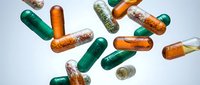 Colorful pharmaceutical capsules and pills scattered on white background showing green and orange medication supplements for healthcare and medical treatment.
