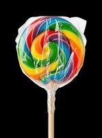 Rainbow swirl lollipop in plastic wrap on a stick, isolated on transparent background, ready for stickers, t-shirt design, clipart, and print on demand use.