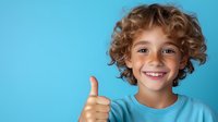 Cheerful young boy with curly hair showing thumbs up gesture against blue background, wearing turquoise t-shirt, expressing positivity and success.