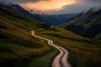 Winding dirt road through green mountain valley at golden sunset with dramatic cloudy sky and rolling hills creating scenic landscape adventure pathway.