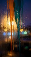Rainy window with vibrant orange and teal streaks of light, bokeh city lights blurred in background, wet glass surface with water droplets, moody evening atmosphere for design projects.