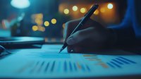 Business person analyzing financial graphs and charts in evening office with bokeh lights, working late on market data and statistics report.