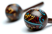 Colorful painted wooden maracas with vibrant folk art patterns on white background, traditional Latin percussion instruments for music and cultural celebrations.