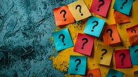 Colorful sticky notes with question marks scattered on textured surface for brainstorming, problem solving and decision making concepts.