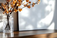 Orange blossom branches in clear glass vase on wooden surface with soft natural window light and shadow play creating minimalist spring atmosphere.