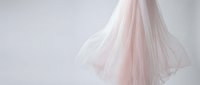 Elegant pink tulle wedding veil flowing gracefully against soft gray background, bridal accessory for romantic ceremony and special occasion photography.