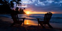 Two adirondack chairs on tropical beach at sunset, silhouetted palm trees frame dramatic orange and purple sky reflecting on wet sand and ocean waves.