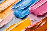 Vibrant acrylic paint strokes in blue, pink, orange and yellow creating textured artistic background for creative projects and design work.