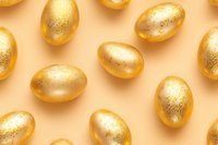 Golden eggs with glitter pattern scattered on peach background. Luxury Easter celebration concept with metallic decorative elements and soft shadows.
