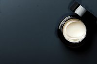 Luxury skincare cream jar with golden texture on dark background for premium cosmetic branding and beauty product marketing campaigns.