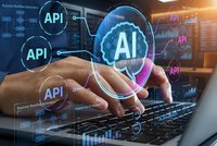 Businessman typing on laptop with holographic AI and API interface icons floating above keyboard representing artificial intelligence programming technology.