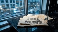 Crumpled newspaper with fake news headline on office desk by window overlooking busy city street at dusk for media literacy and misinformation concepts.