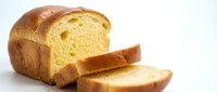 Fresh sliced brioche bread loaf with golden yellow crumb and buttery texture on white background isolated for bakery and food design projects.