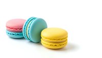 Colorful French macarons in pink, turquoise and yellow arranged on white background. Sweet pastry dessert cookies isolated for bakery menu design.