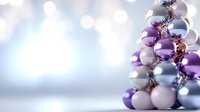 Elegant Christmas tree made of purple, silver and white baubles on blurred winter background with bokeh lights and copy space for seasonal greetings.