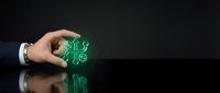 Business hand holding green eco-friendly symbol on dark reflective surface representing sustainable corporate responsibility and environmental awareness.