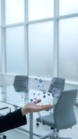 Businessperson holding digital icons representing innovation, technology, and interconnected ideas in modern office with large windows and blurred workspace background.