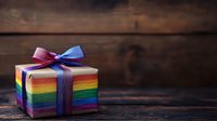 Rainbow striped gift box with purple ribbon bow on rustic wooden surface, suitable for celebrations, holidays, and festive occasions.