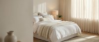 Serene bedroom with neutral tones, white bedding, layered textures, natural light from sheer curtains, minimalist decor, and warm wooden accents for home design inspiration.
