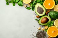 Fresh avocado halves with citrus fruits, nuts and green herbs arranged on light background. Healthy organic food ingredients for nutritious meals and recipes.