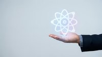 Businessman hand presenting glowing atomic structure symbol representing science, technology innovation and nuclear energy concepts for presentations.