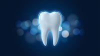 Glowing white tooth with blue light effect on dark background with bokeh lights for dental care and oral health concepts.