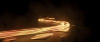 Golden light trails creating dynamic curved motion paths against dark background for technology and speed concepts.