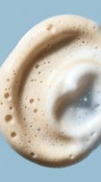 Creamy coffee foam swirl with bubbles on light blue background for beverage advertising and cafe marketing materials.