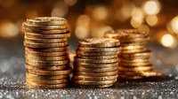 Stacks of golden coins arranged in ascending order on textured surface with warm bokeh lights creating wealth and investment concept for financial planning.