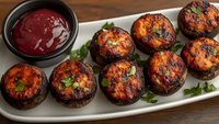 Grilled stuffed mushrooms with herbs and spicy sauce served on white platter, perfect appetizer for restaurants, catering menus and cooking blogs.