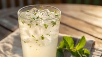 Refreshing mint lemonade with fresh herbs in glass on wooden table, summer drink cocktail beverage for hot weather cooling hydration outdoor dining.