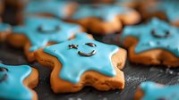 Cute star-shaped gingerbread cookies with bright blue icing and smiling faces scattered on dark surface for holiday baking and festive celebrations.
