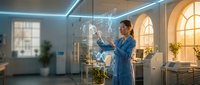 Young Asian female scientist in blue lab coat analyzing holographic data display in modern research laboratory with advanced technology interface.