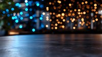 Blurred festive lights creating magical bokeh effect with empty dark surface in foreground, perfect for product placement or holiday designs.