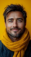 Smiling Hispanic man with beard wearing yellow knitted scarf against vibrant yellow background. Close-up portrait showing genuine happiness and confidence. Great for lifestyle advertising.