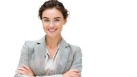 Young professional woman in light gray business suit and beige blouse smiling confidently with arms crossed, expressing leadership and success against white background.