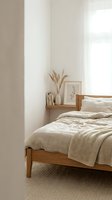 Minimalist bedroom interior with wooden bed frame, neutral bedding, dried pampas grass in ceramic vase, framed botanical art, and natural light from window for home decor and lifestyle design.
