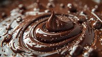 Swirling melted chocolate cream with spiral pattern and droplets creates rich texture and glossy surface for confectionery and dessert photography.
