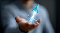 Glowing blue rocket hologram floating above open palm against dark background, representing business startup, innovation and future technology concept.
