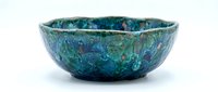 Turquoise ceramic bowl with textured glaze and organic surface patterns, isolated on white background for design and product use.
