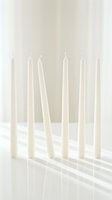 Elegant white taper candles arranged in minimalist composition with soft shadows on clean background for home decor and lifestyle concepts.