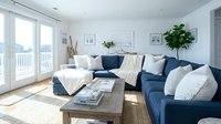 Young family living room with blue sectional sofa, wooden coffee table, and coastal decor. Bright, airy space with natural light from glass doors, perfect for home design and interior styling inspiration.