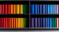 Colorful rows of books arranged in rainbow spectrum order on dark wooden shelves, creating vibrant gradient display for modern interior design and library decoration.
