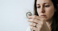Woman examining hair loss strand with concern, healthcare and beauty treatment concept for thinning hair solutions.