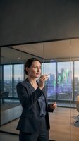 Professional businesswoman analyzing financial growth charts on transparent digital display in modern corporate office with city skyline view.