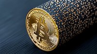 Golden cryptocurrency coin on digital binary code background, macro view showing detailed texture and reflective metallic surface in dramatic lighting.